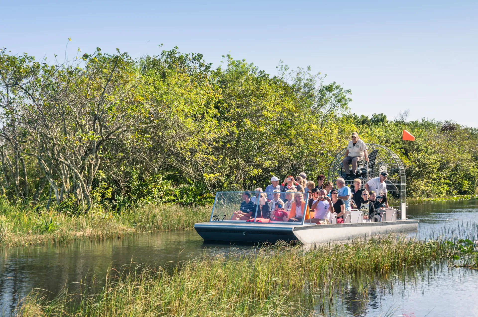 Tourists enjoying Everglades airboat rides during a guided Everglades boat tour through the Florida Everglades wetlands