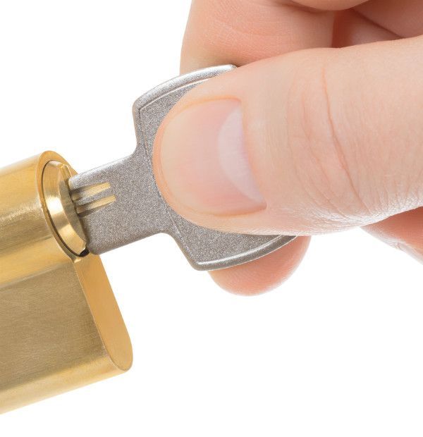 A person is holding a key in front of a lock