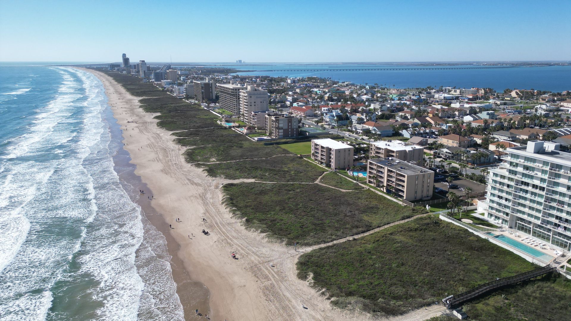 an aerial view of a beach with a city in the background .
