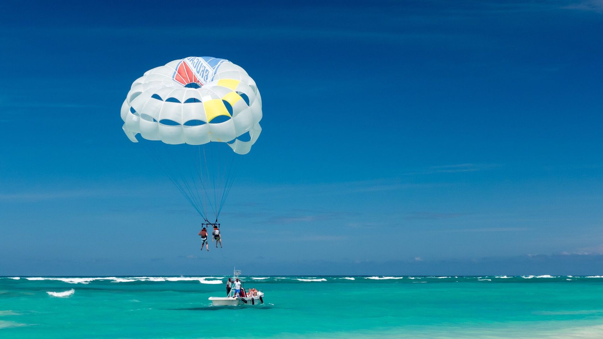 a couple is parasailing over the ocean .
