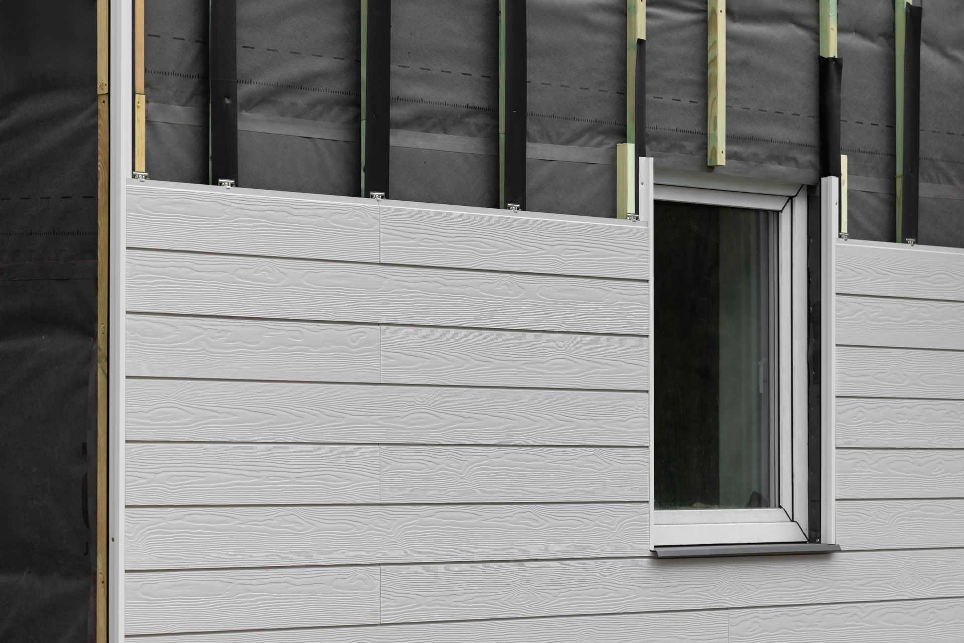 A close up of a house with a window and siding.