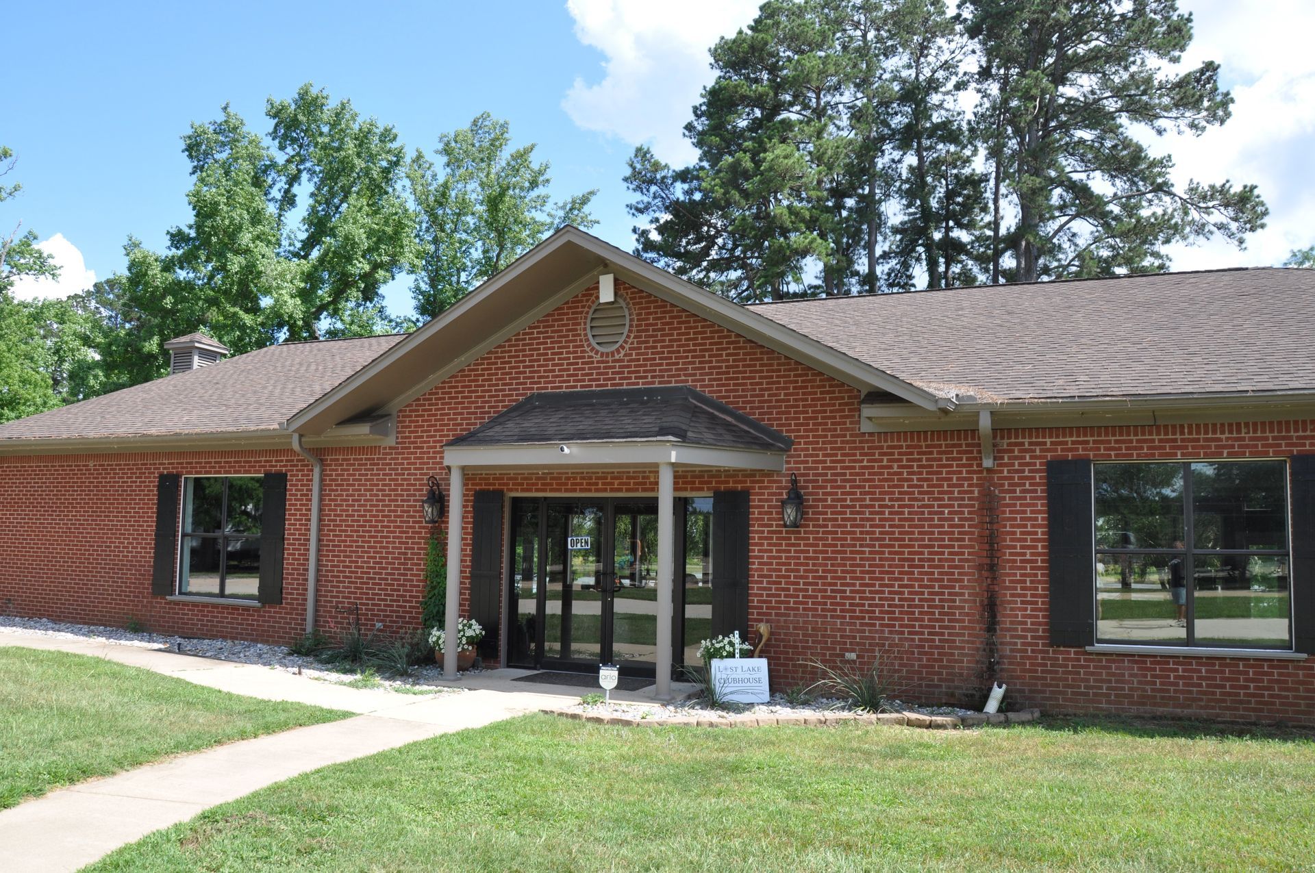 A brick house with a brown roof and a walkway leading to it