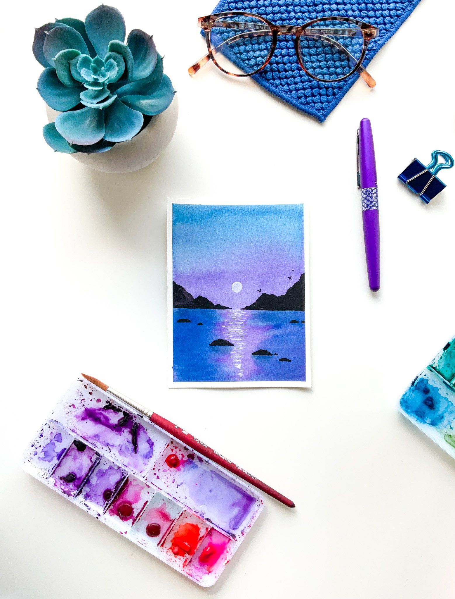 Flatlay blue and purple lake and mountain landscape watercolor painting