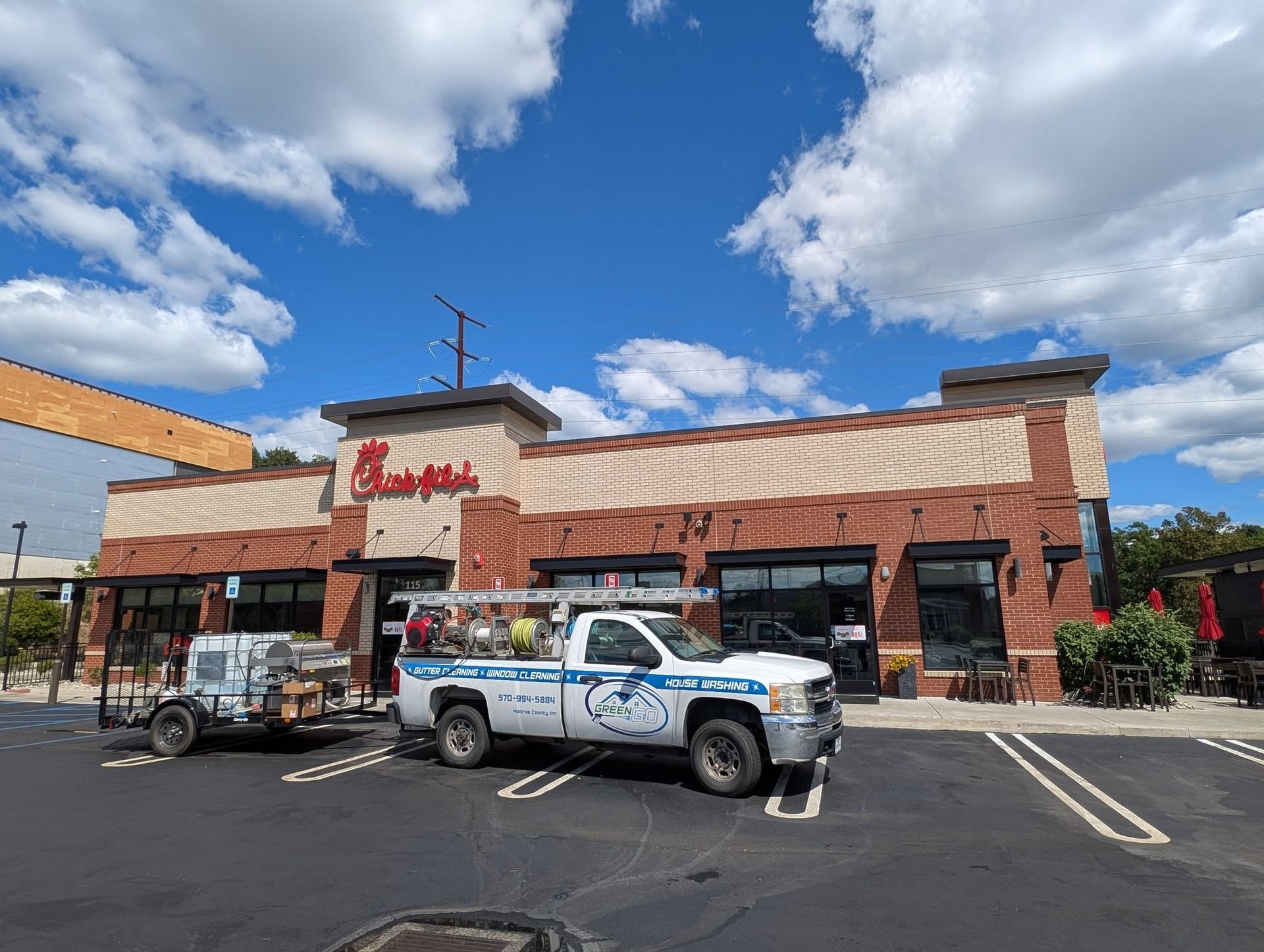 Chick-fil-A restaurant with a white service truck parked in front on a sunny day.