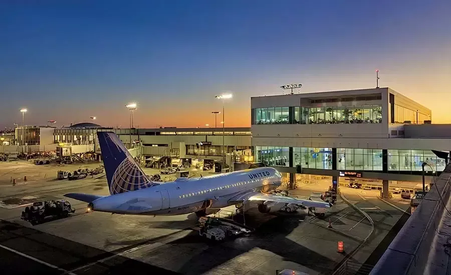 An airplane at an airport terminal at dusk, United Airlines livery visible.