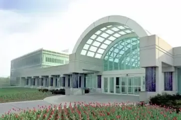 Exterior of the National Security Agency headquarters, with a large glass arch entrance and green grass.