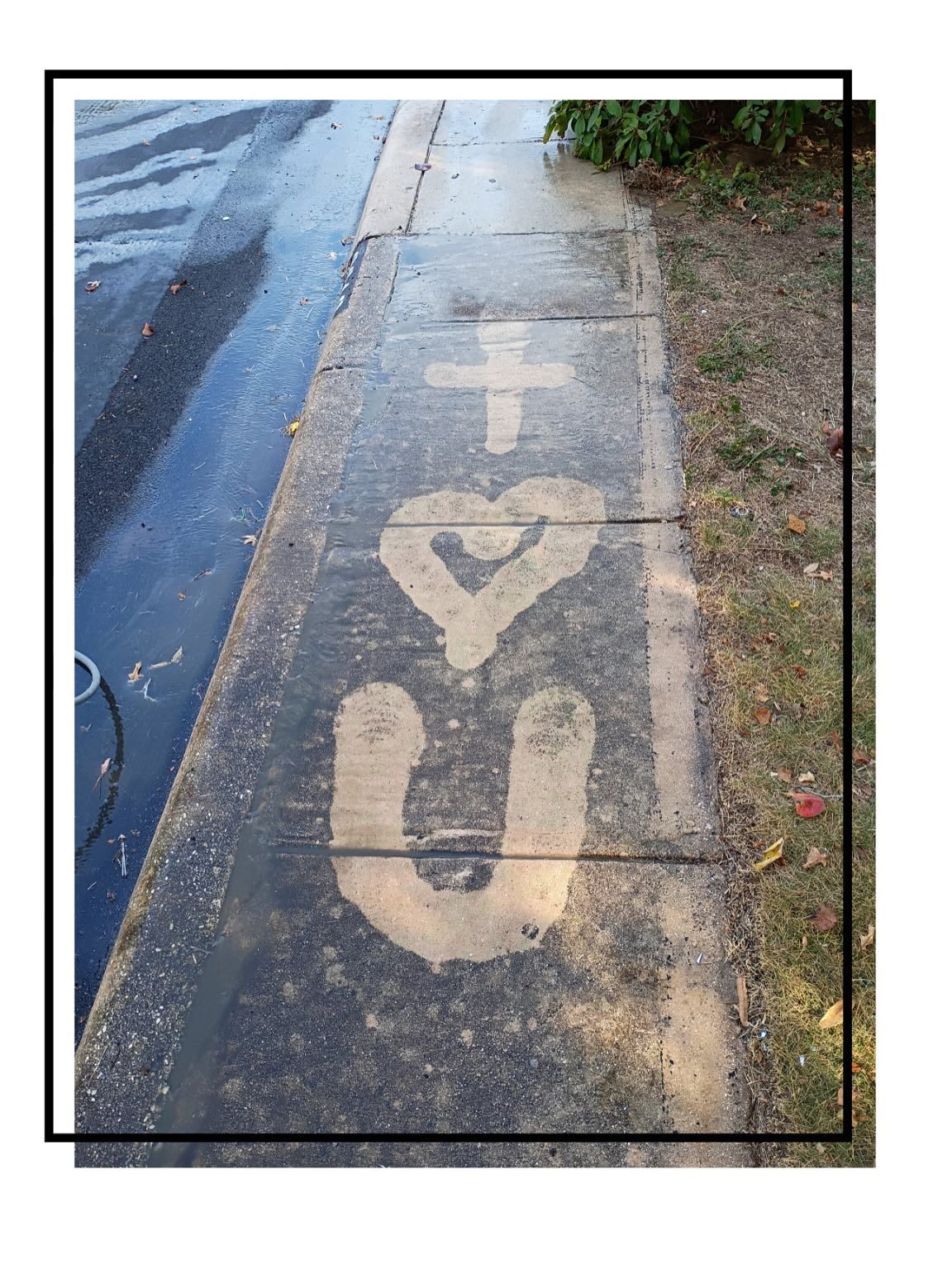 A light-colored, stencil-style graphic of a cross, a heart, and the letter 