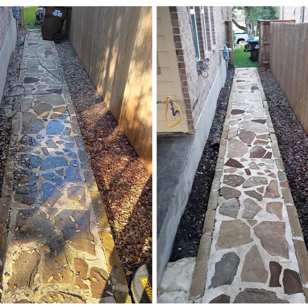 Before and after view of a stone walkway between a house and a wooden fence, showing a thorough pressure wash cleaning.