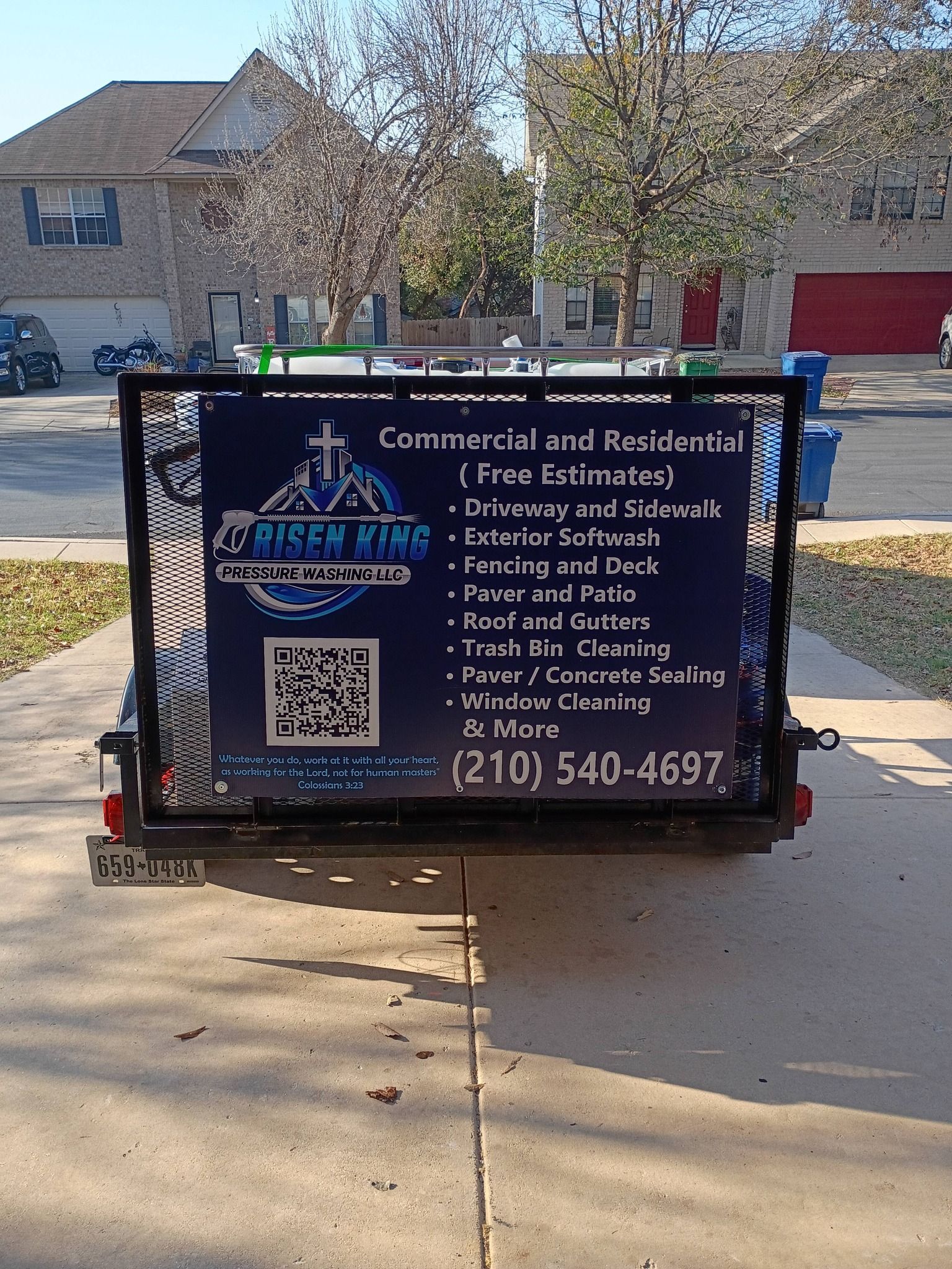 A utility trailer on a suburban driveway features a sign for Risen King Services, listing cleaning services and a phone number.