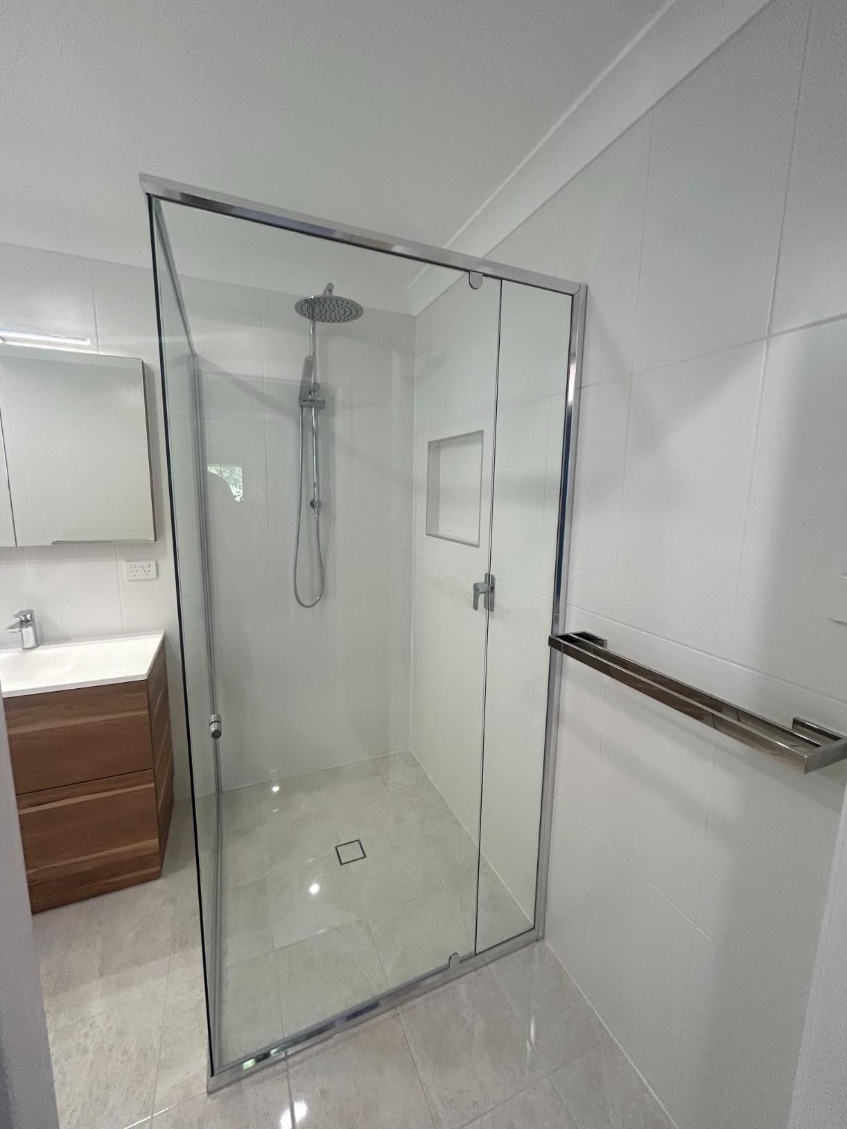 A Bathroom With a Walk in Shower and a Sink — BK Build Group in Sawtell, NSW