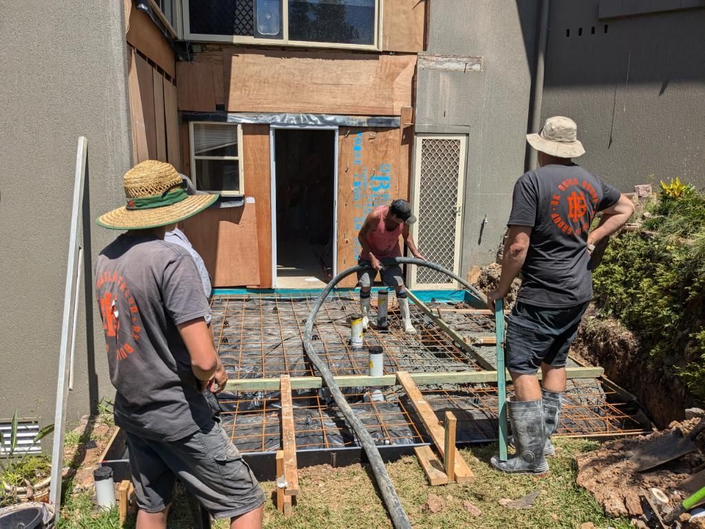 A Group of Construction Workers Are Working on a Concrete Floor — BK Build Group in Bellingen, NSW