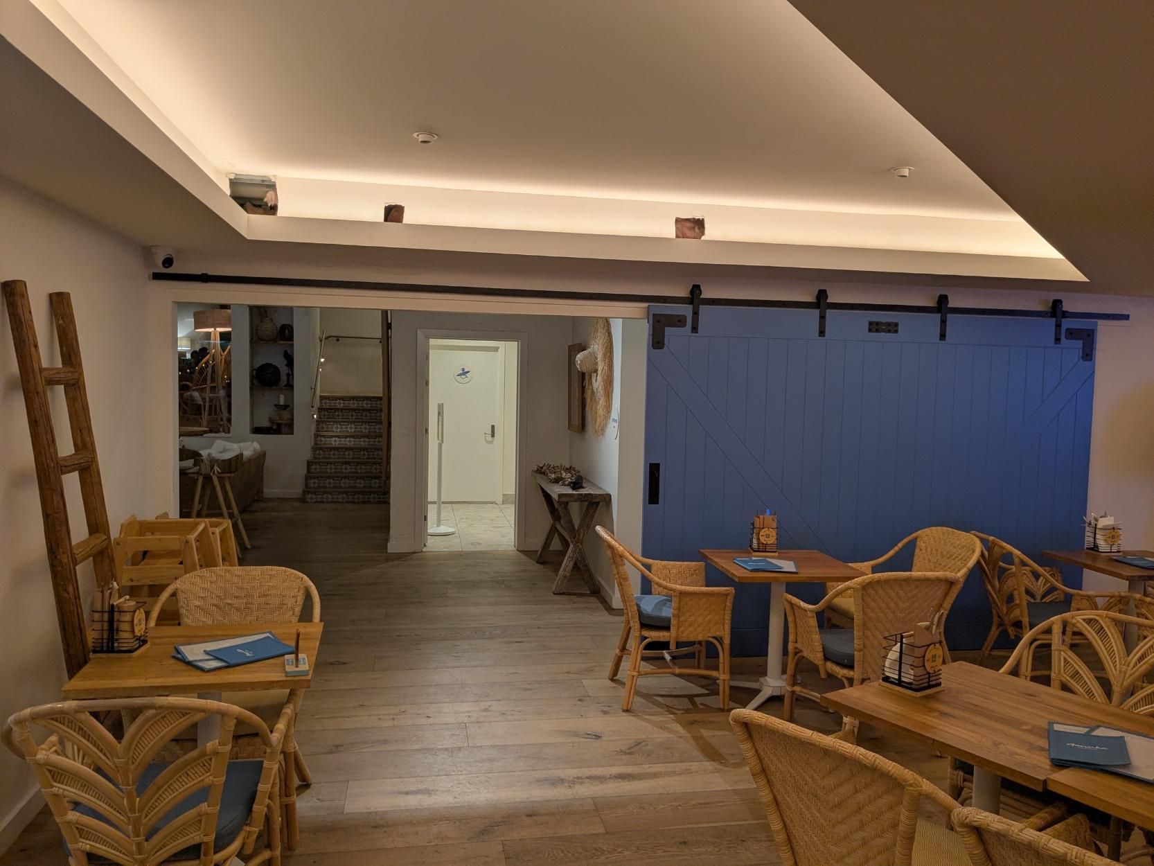 A Restaurant With Tables and Chairs and a Blue Wall — BK Build Group in Coffs Harbour, NSW