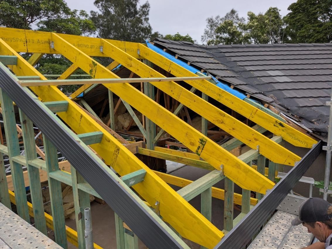 A Man is Working on the Roof of a House Under Construction — BK Build Group in Coffs Harbour, NSW