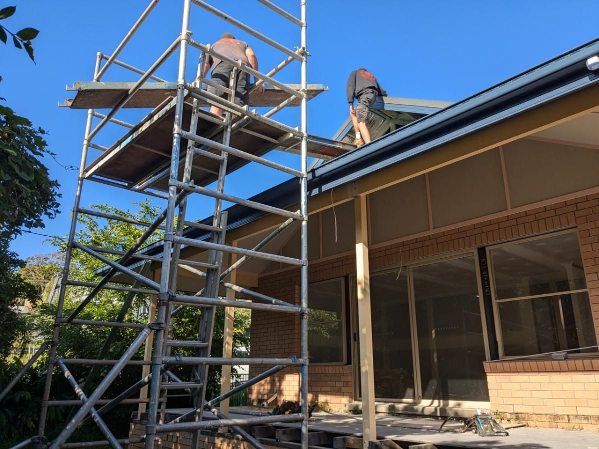 A Group of Men Are Working on the Roof of a House — BK Build Group in Sawtell, NSW