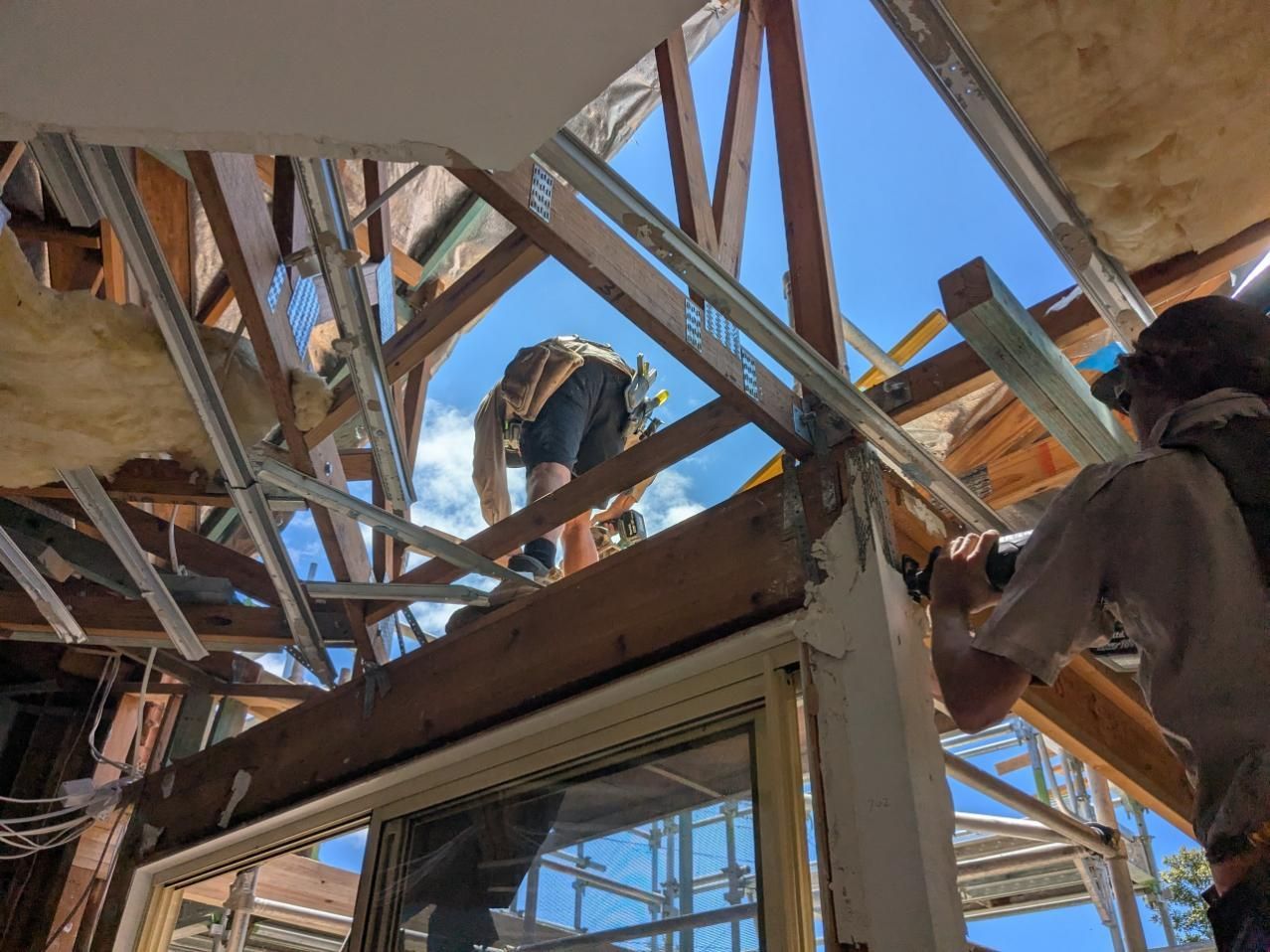 A Group of Construction Workers Are Working on the Roof of a Building — BK Build Group in Nambucca Heads, NSW