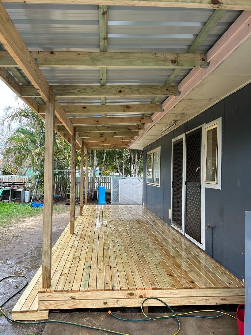 A Wooden Deck With a Metal Roof is Under Construction on the Side of a House — BK Build Group in Coffs Harbour, NSW