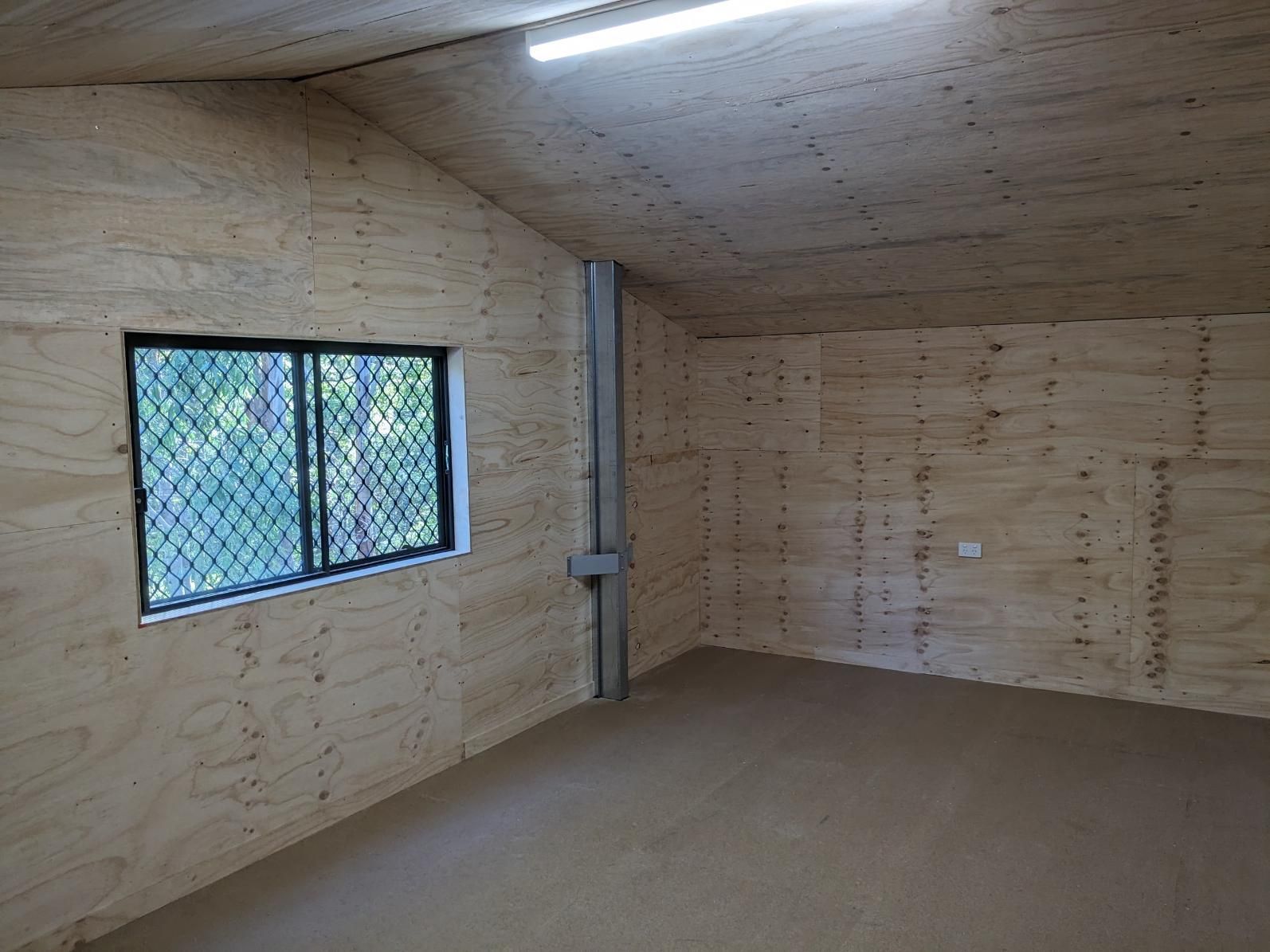 An Empty Room With Wooden Walls and a Window — BK Build Group in Nambucca Heads, NSW