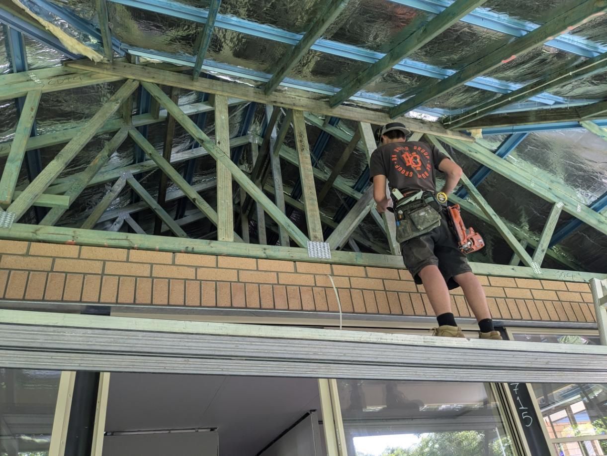 A Man is Standing on the Roof of a Building Under Construction — BK Build Group in Sawtell, NSW