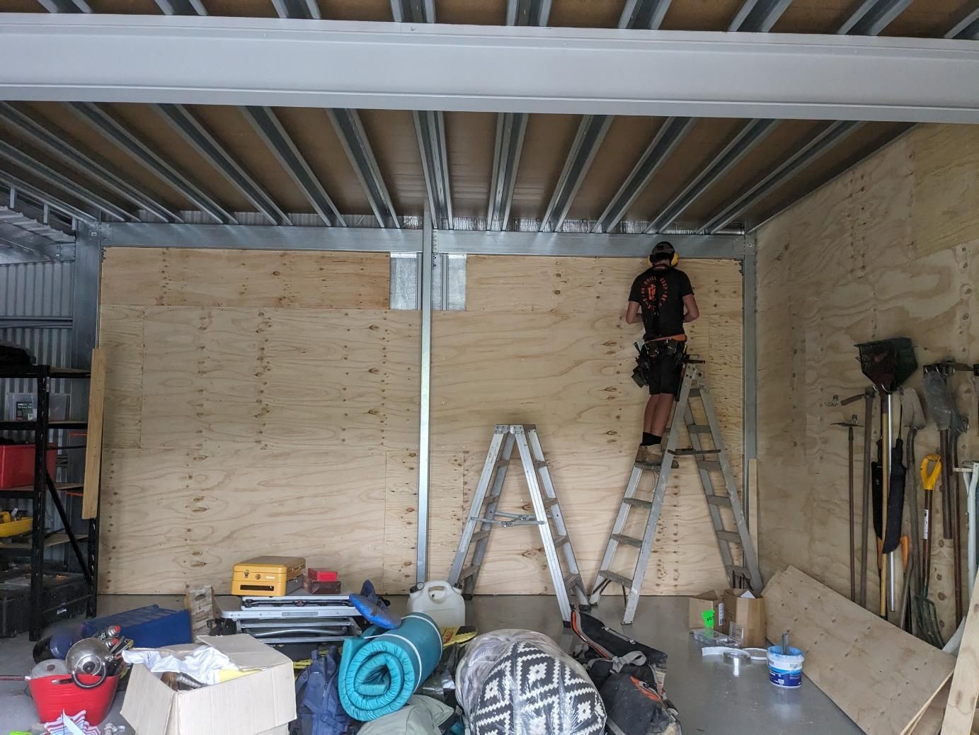 A Man is Standing on a Ladder in a Garage — BK Build Group in Sawtell, NSW