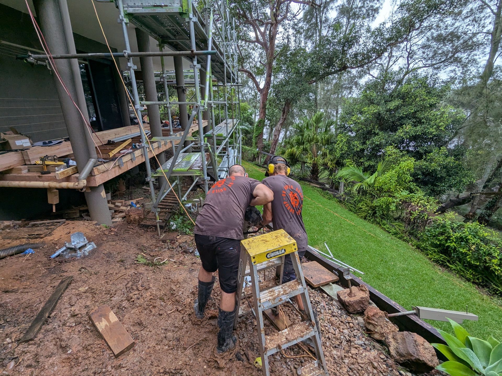 Two Men Are Working on a Ladder in Front of a House — BK Build Group in Coffs Harbour, NSW