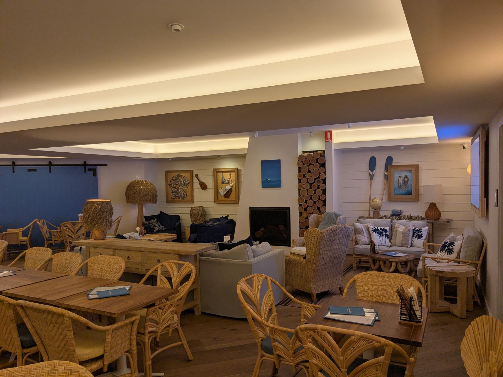 A Large Room With Tables and Chairs and a Fireplace — BK Build Group in Coffs Harbour, NSW