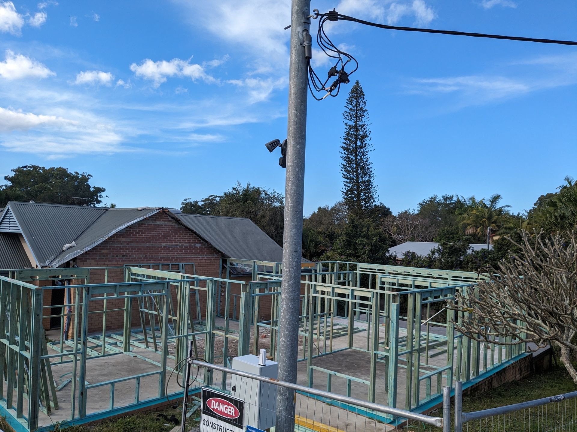 A House is Being Built in a Residential Area With a Fence Around It — BK Build Group in Coffs Harbour, NSW