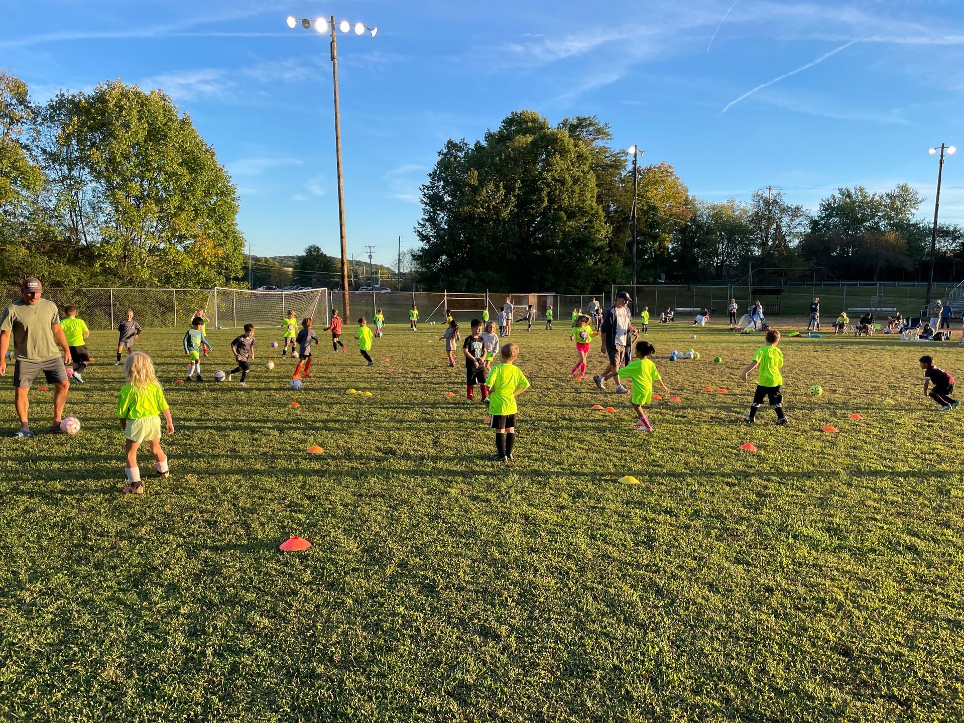 A group of children are playing soccer on a field.