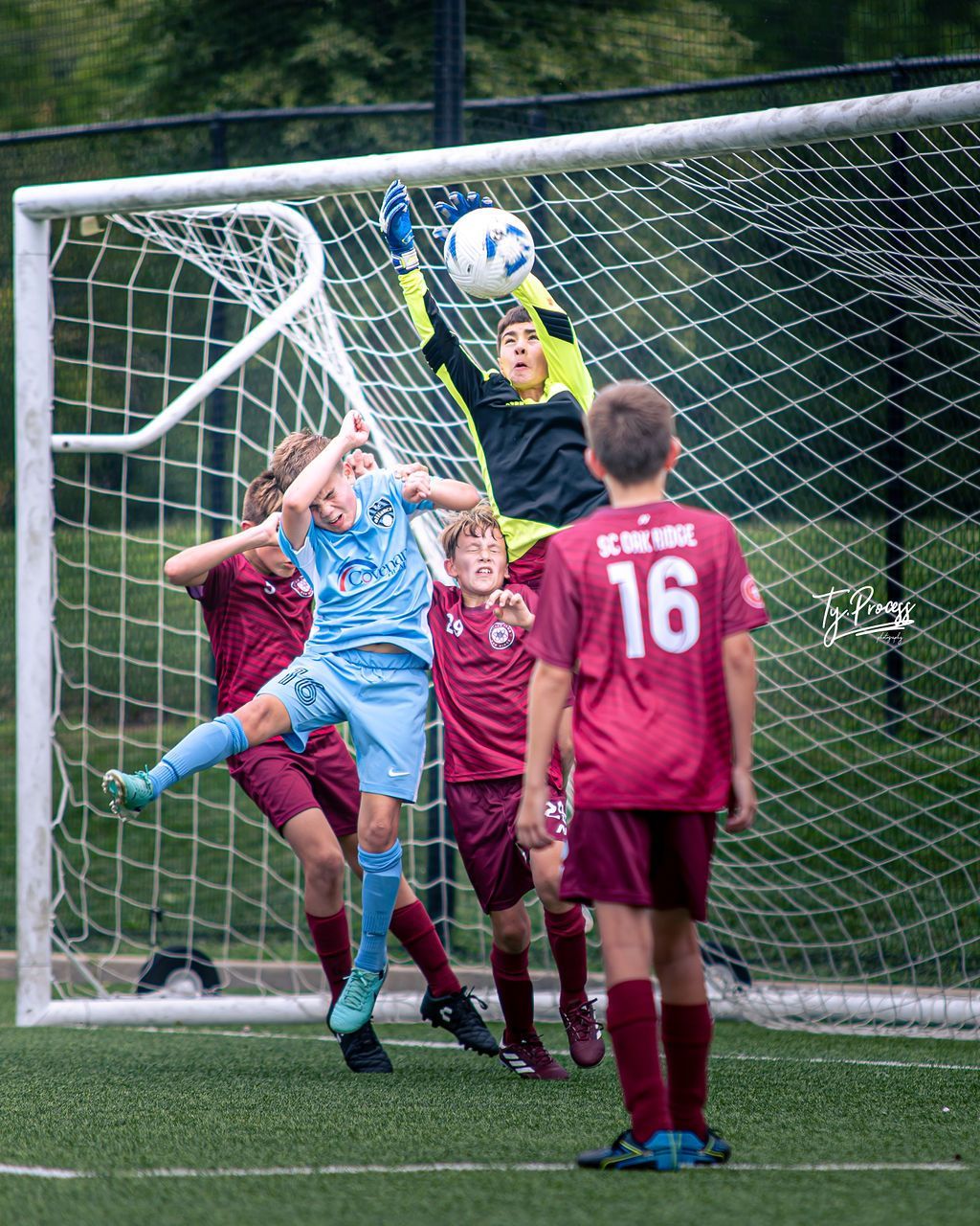 A group of young boys are playing soccer on a field.