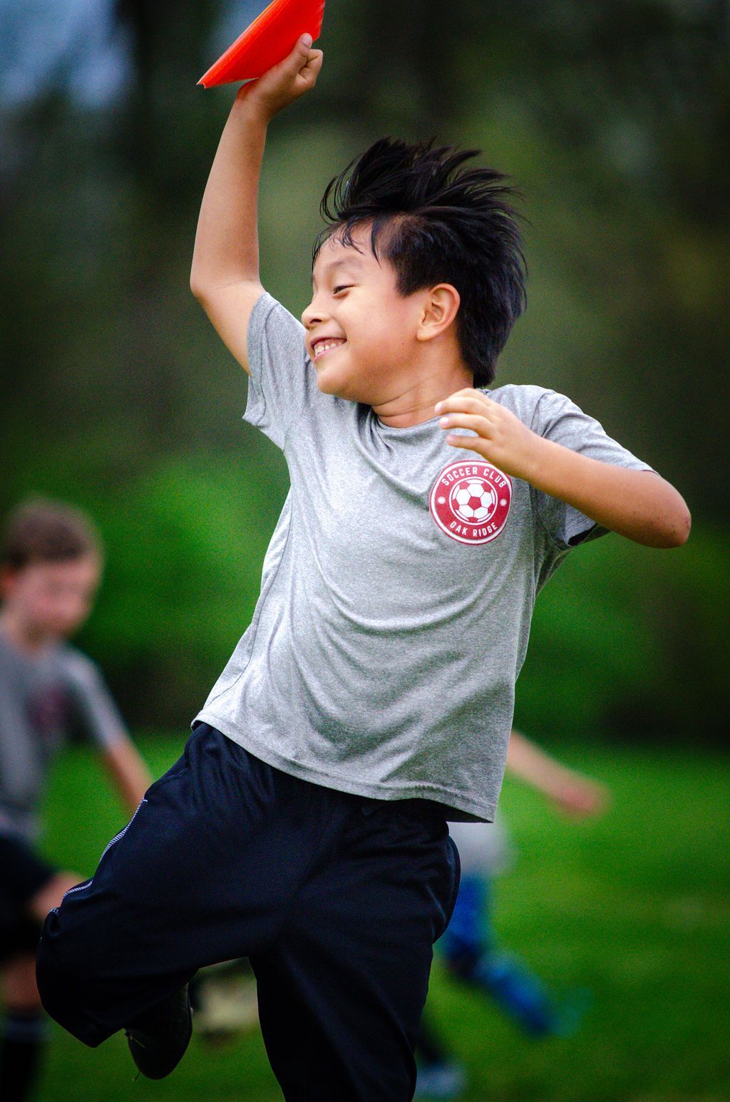 A young boy is throwing a frisbee in the air.