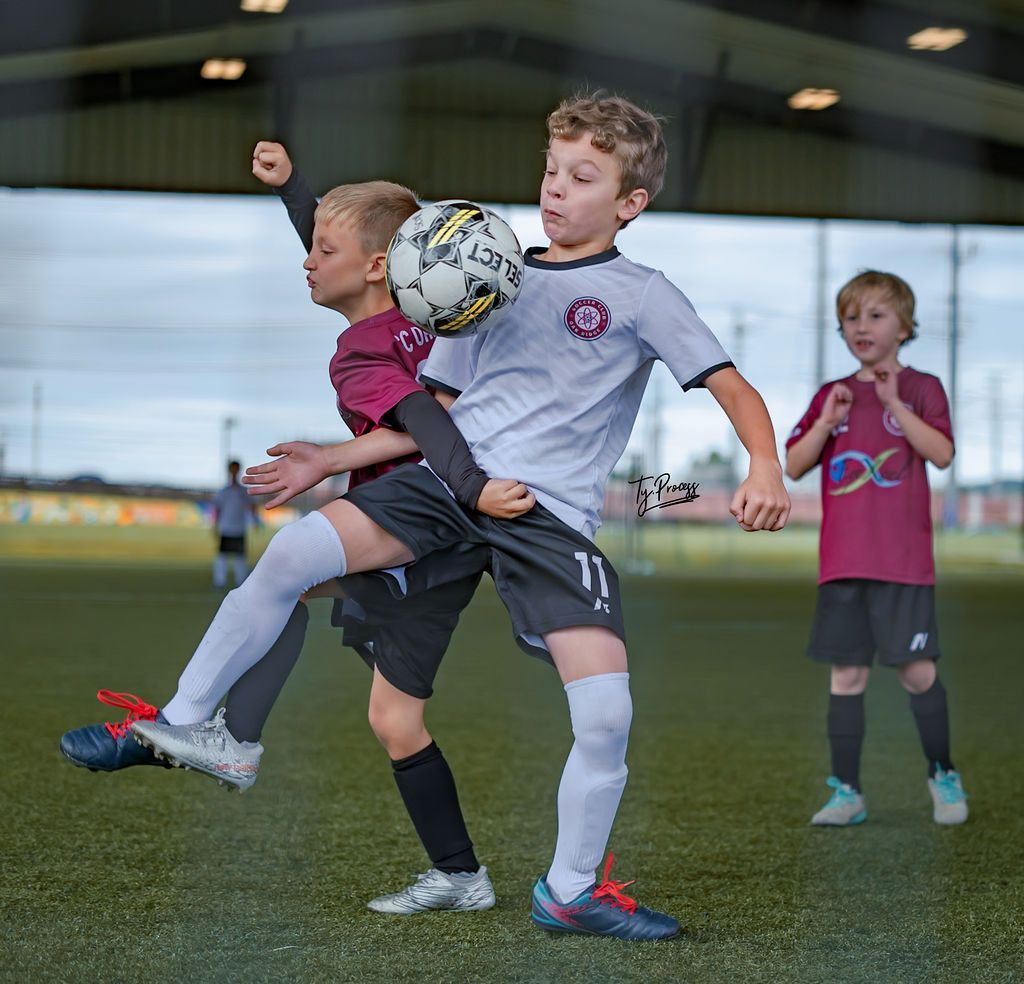 A group of young boys are playing soccer on a field.