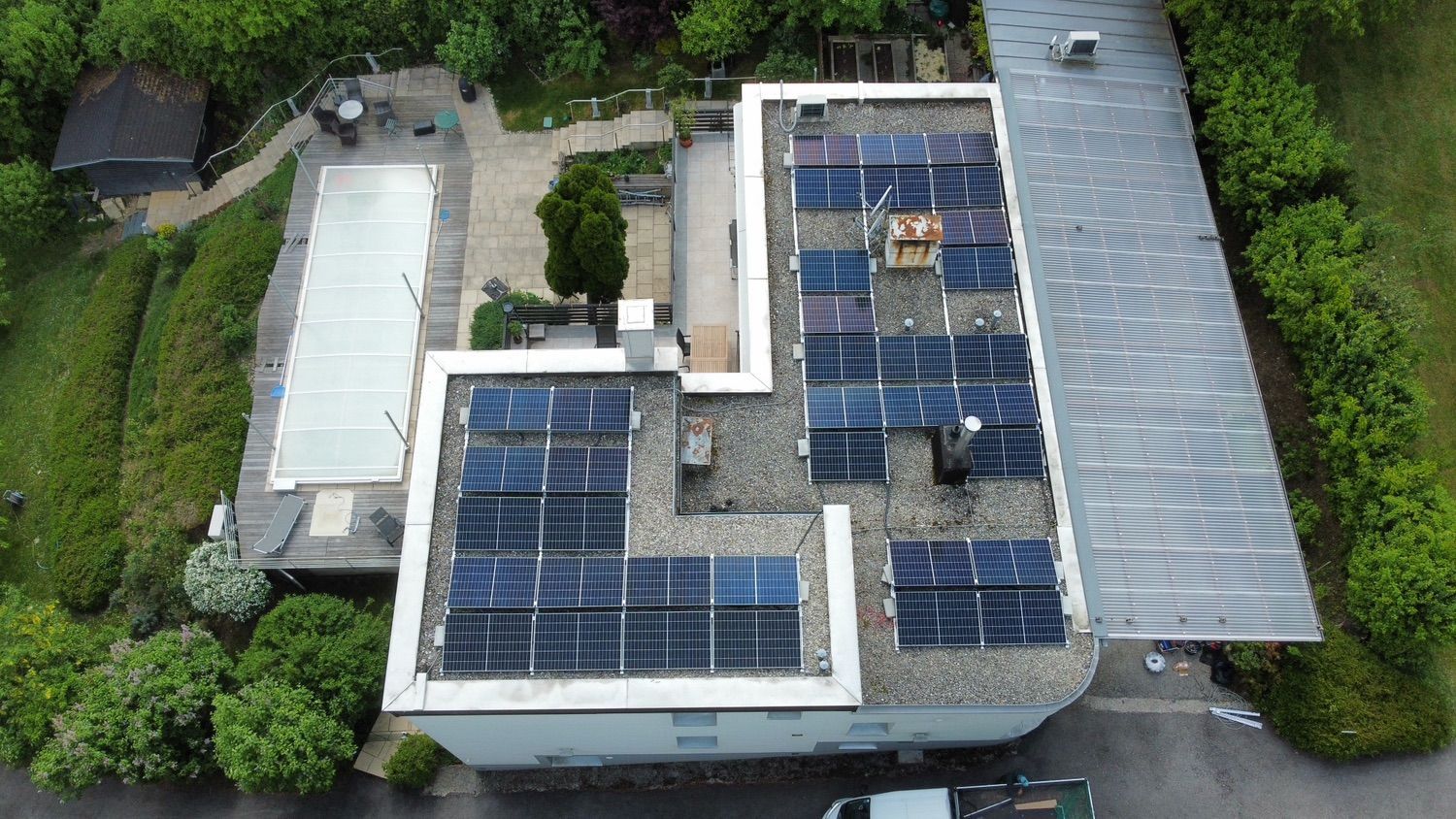 Eine Luftaufnahme eines Hauses mit Solarmodulen auf dem Dach.