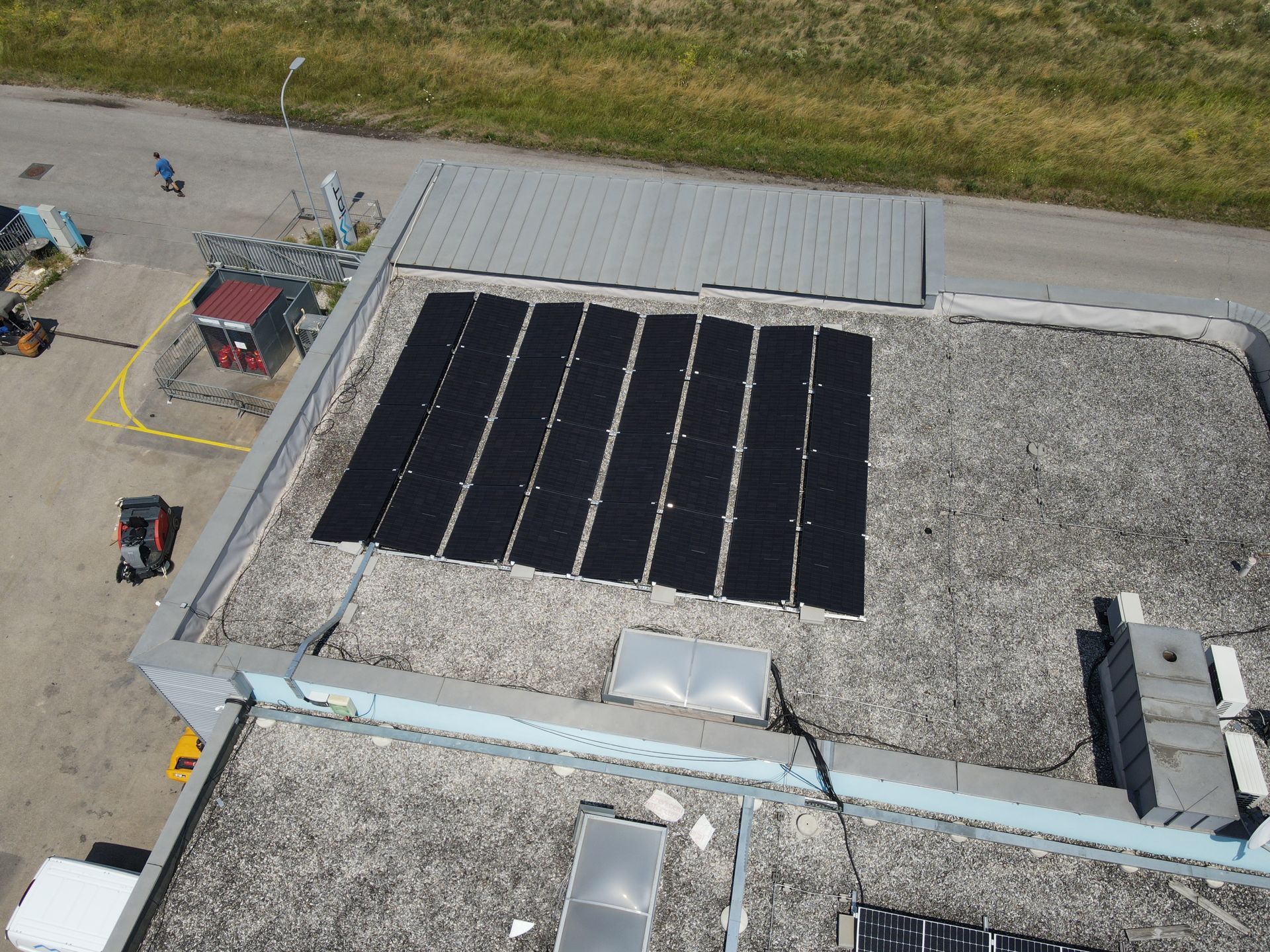 Eine Luftaufnahme eines Gebäudes mit Solarmodulen auf dem Dach.