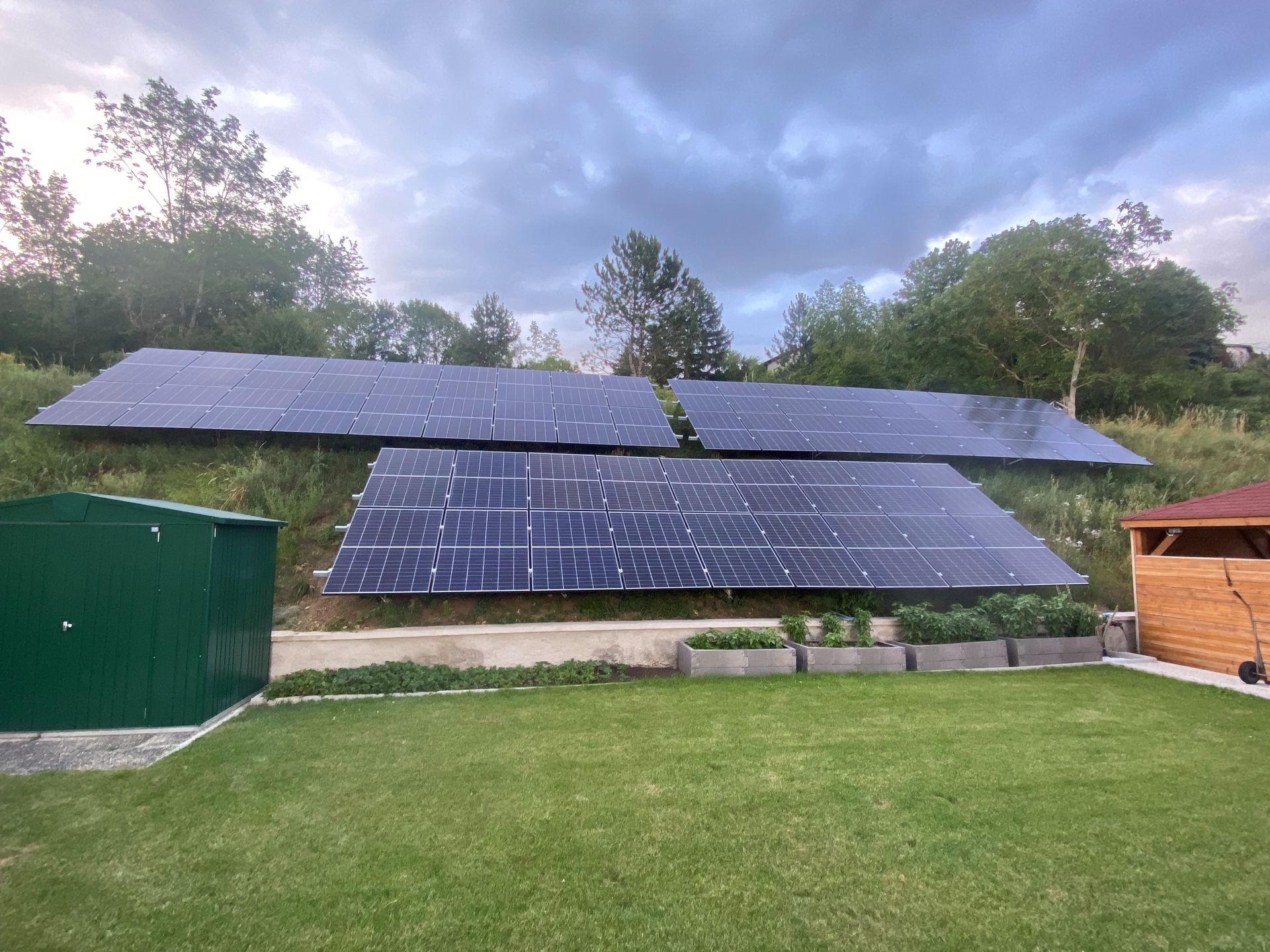 Auf einem üppigen grünen Feld stehen mehrere Solarmodule.