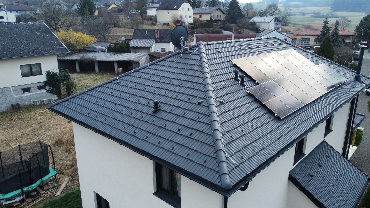 Eine Luftaufnahme eines Hauses mit Solarmodulen auf dem Dach.
