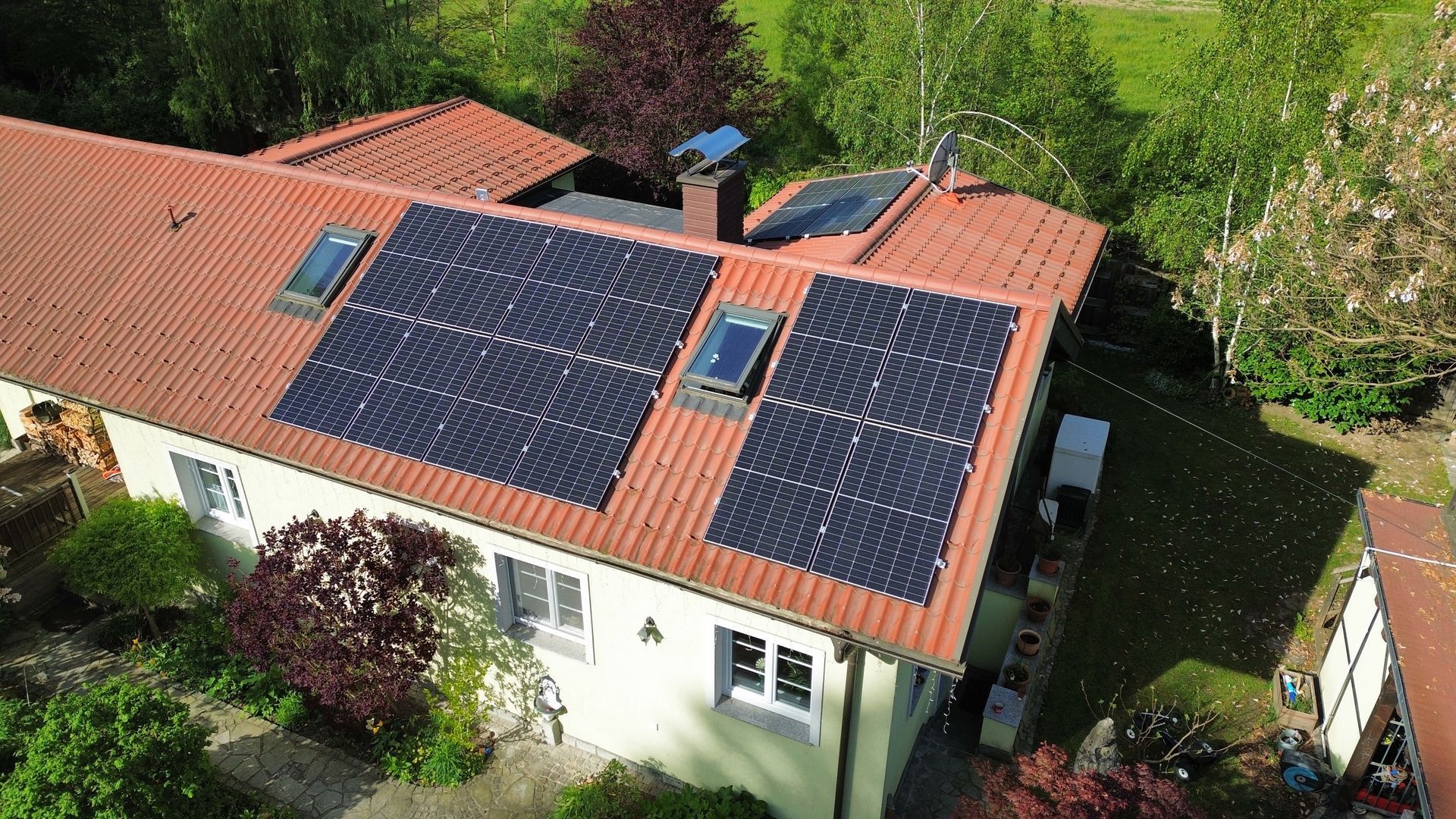 Eine Luftaufnahme eines Hauses mit Solarmodulen auf dem Dach.