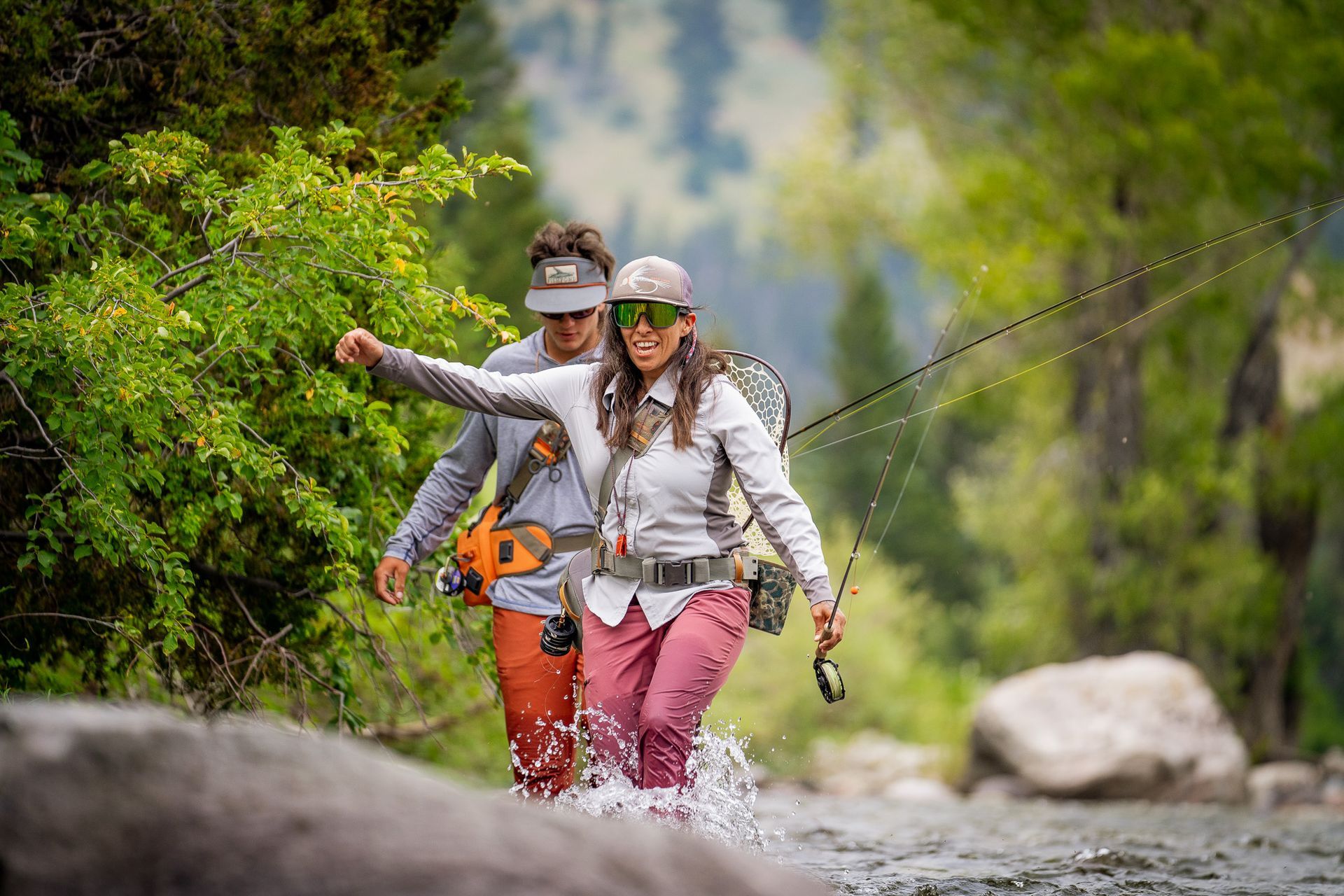 2 People Fly Fishing With a Fish on the line.