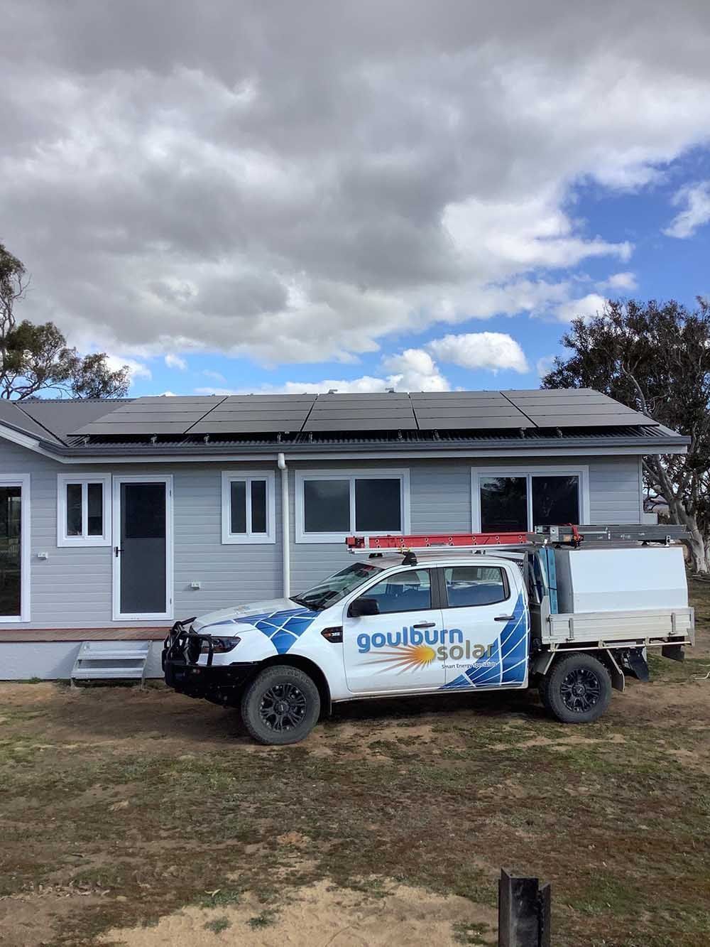 Goulburn Solar Truck Parked In Front Of A House With Solar Panels On The Roof — Goulburn Solar In Marulan, NSW