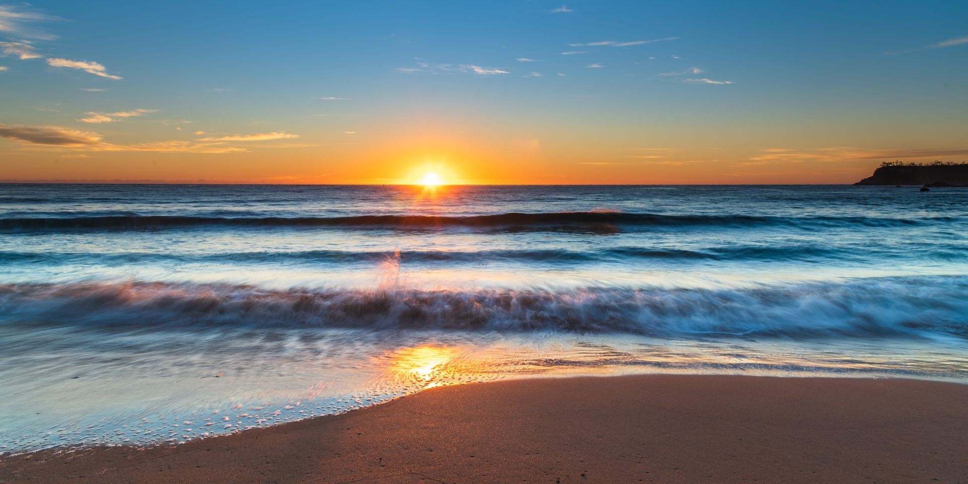 Sun Setting Over The Ocean And The Waves Crashing On The Beach — Goulburn Solar In Batemans Bay, NSW