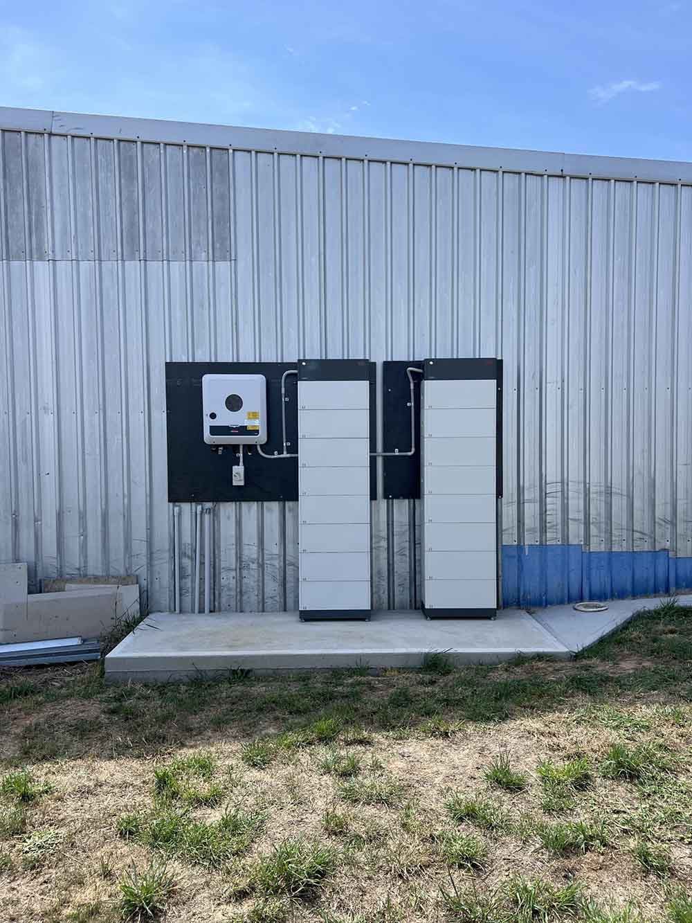 Two Solar Panel Inverters Mounted On The Side Of A Building — Goulburn Solar In Goulburn, NSW