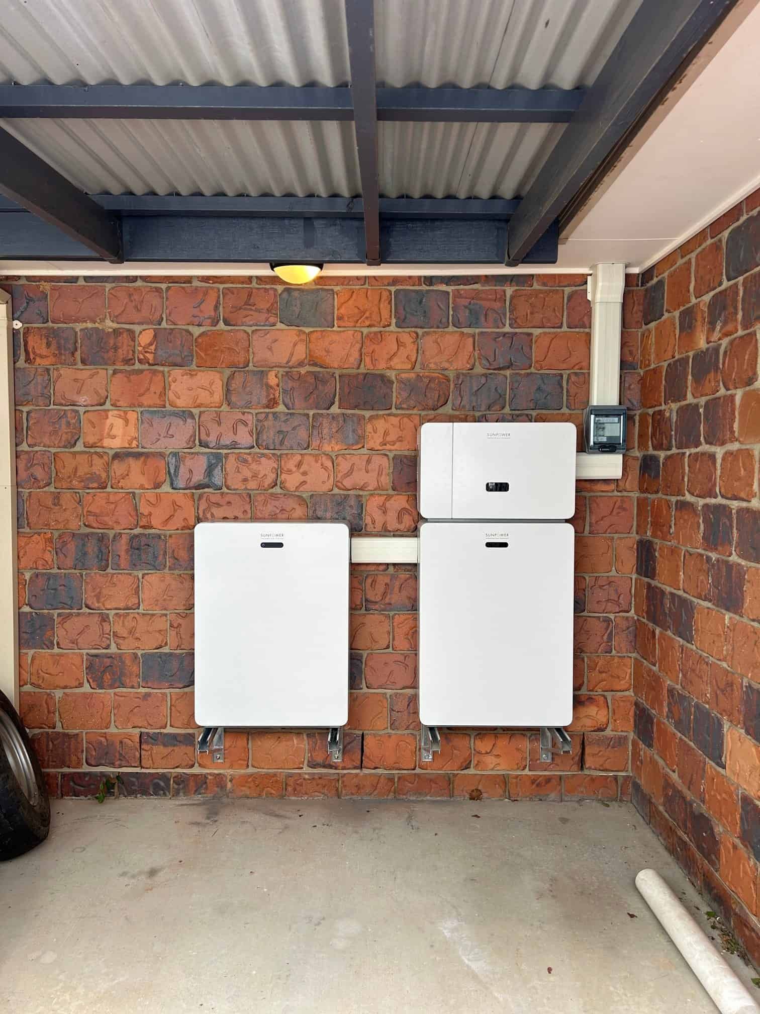 Two Solar Panels Are Mounted On A Brick Wall In A Garage — Goulburn Solar In Goulburn, NSW