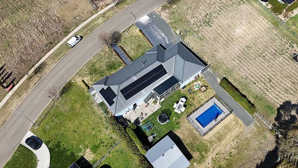 An Aerial View Of A House With Solar Panels On The Roof And A Pool — Goulburn Solar In Crookwell, NSW