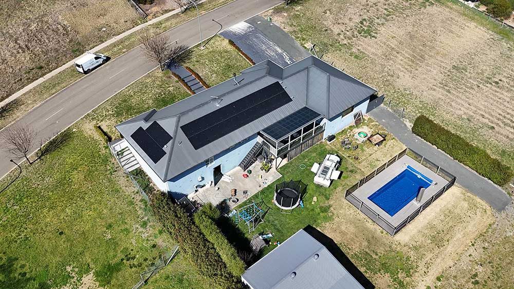 Aerial View Of A House With A Pool And Solar Panels On The Roof — Goulburn Solar In Goulburn, NSW