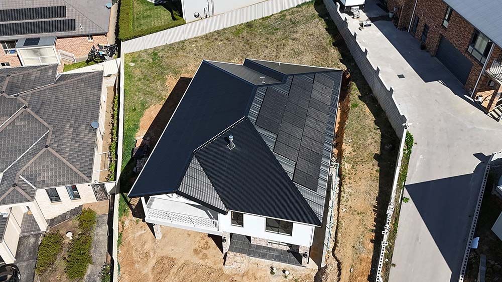 An Aerial View Of A House With Solar Panels In A Residential Area — Goulburn Solar In Goulburn, NSW