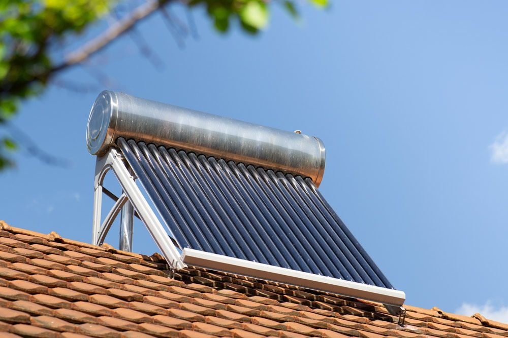 A Solar Water Heater is Sitting on Top of a Tiled Roof — Goulburn Solar In Goulburn, NSW