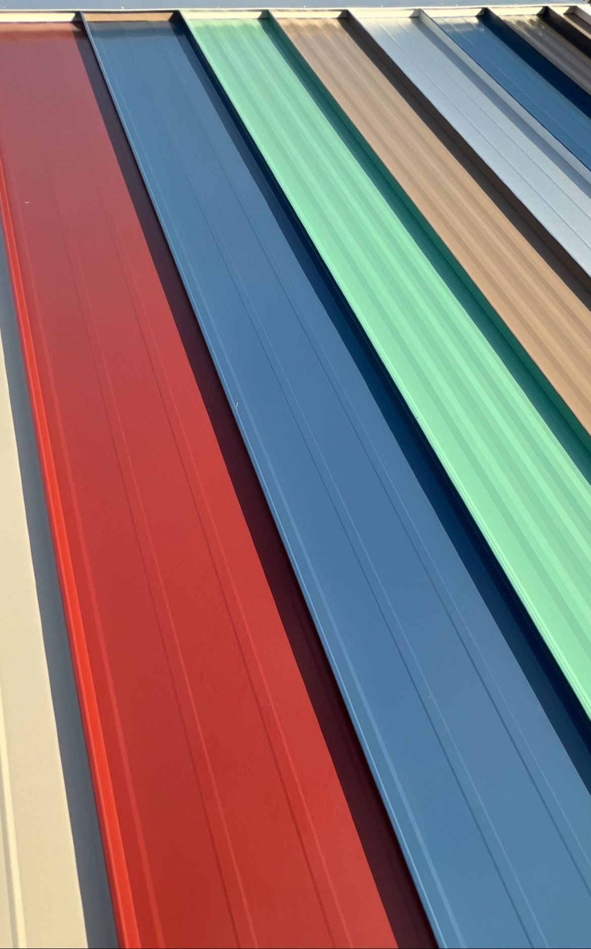 Colorful metal roofing samples displayed outdoors.