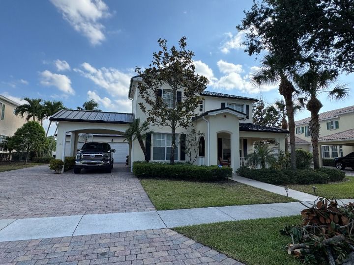 Two-story house with a driveway, garage, lawn, and a car parked in the driveway.