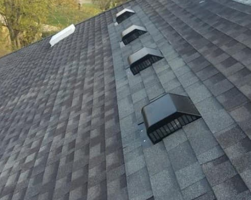 Gray asphalt shingle roof with black vents.