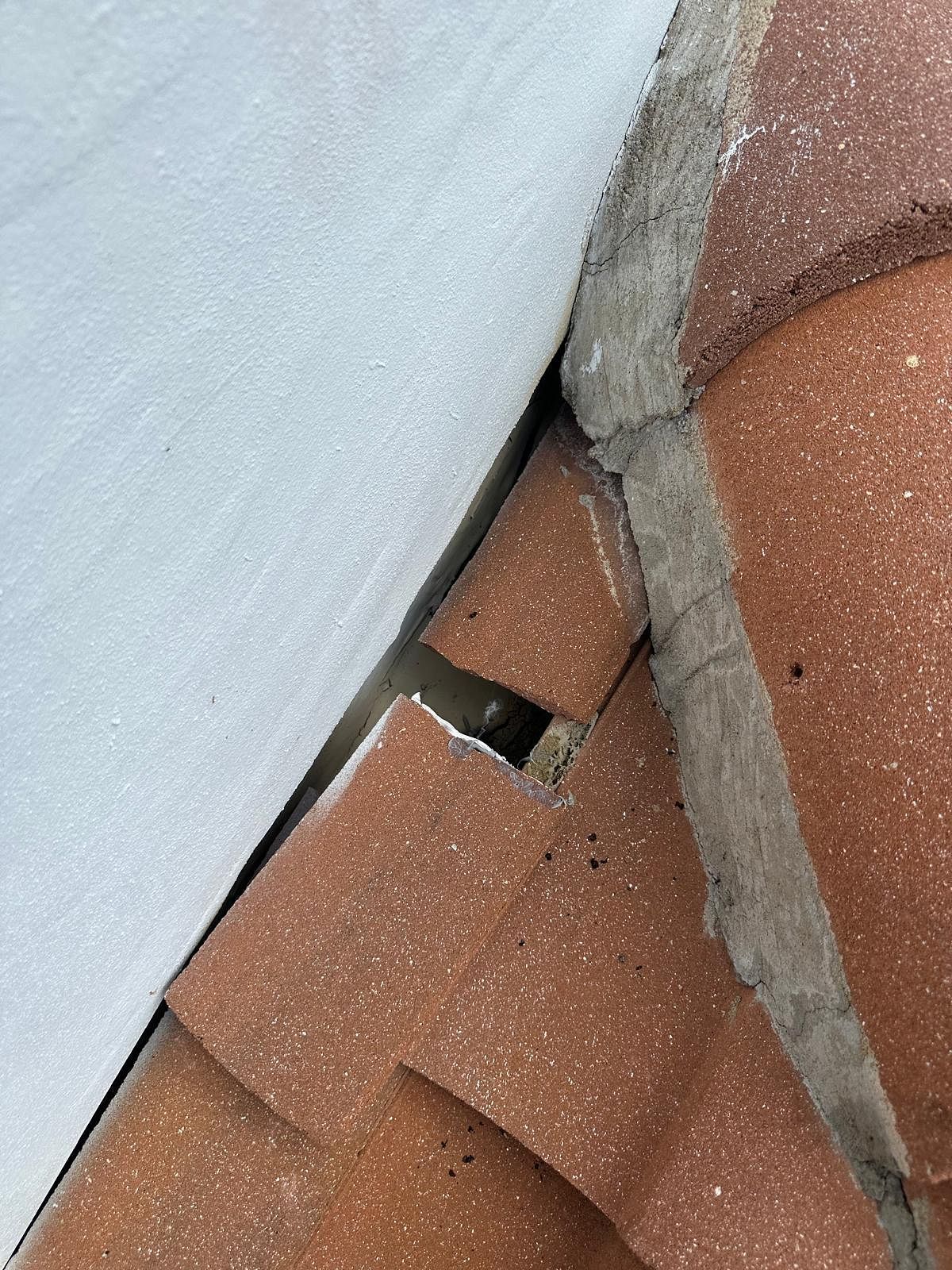 Close-up view showing orange brick and white material with a gap between them.