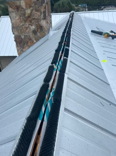 Metal roof with gutter guard installation.