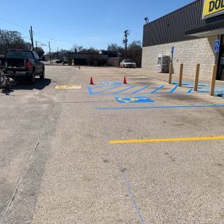 Parking lot with handicap spaces painted blue, orange cones, and a Dollar General store.